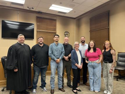  Photo: Judge Patrick Lee, graduate Eduardo Acosta Paez, graduate Jacob Miller, graduate Taylor Warren, Problem-Solving Court Coordinator Susan Huber, Probation Officer Isaac Obermiller, graduate Hannah Schrader, and Officer Ralyn Tennant.