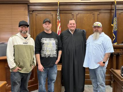 Photo: Graduates James, Bradley, and Derek with Judge Andrew Butler.