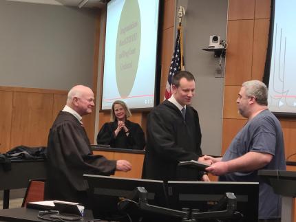 Judge Ryan Post, Judge John Colborn, Judge Darla Ideus, and a drug court graduate.