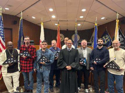 Judge Horacio Wheelock standing with the Veterans Treatment Court graduates.