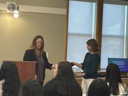 Jamie Bahm of UNL presenting Melanie Kirk the Bob Moyer award.